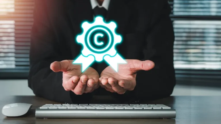 Person in formal attire holding glowing copyright symbol above keyboard and mouse on desk.